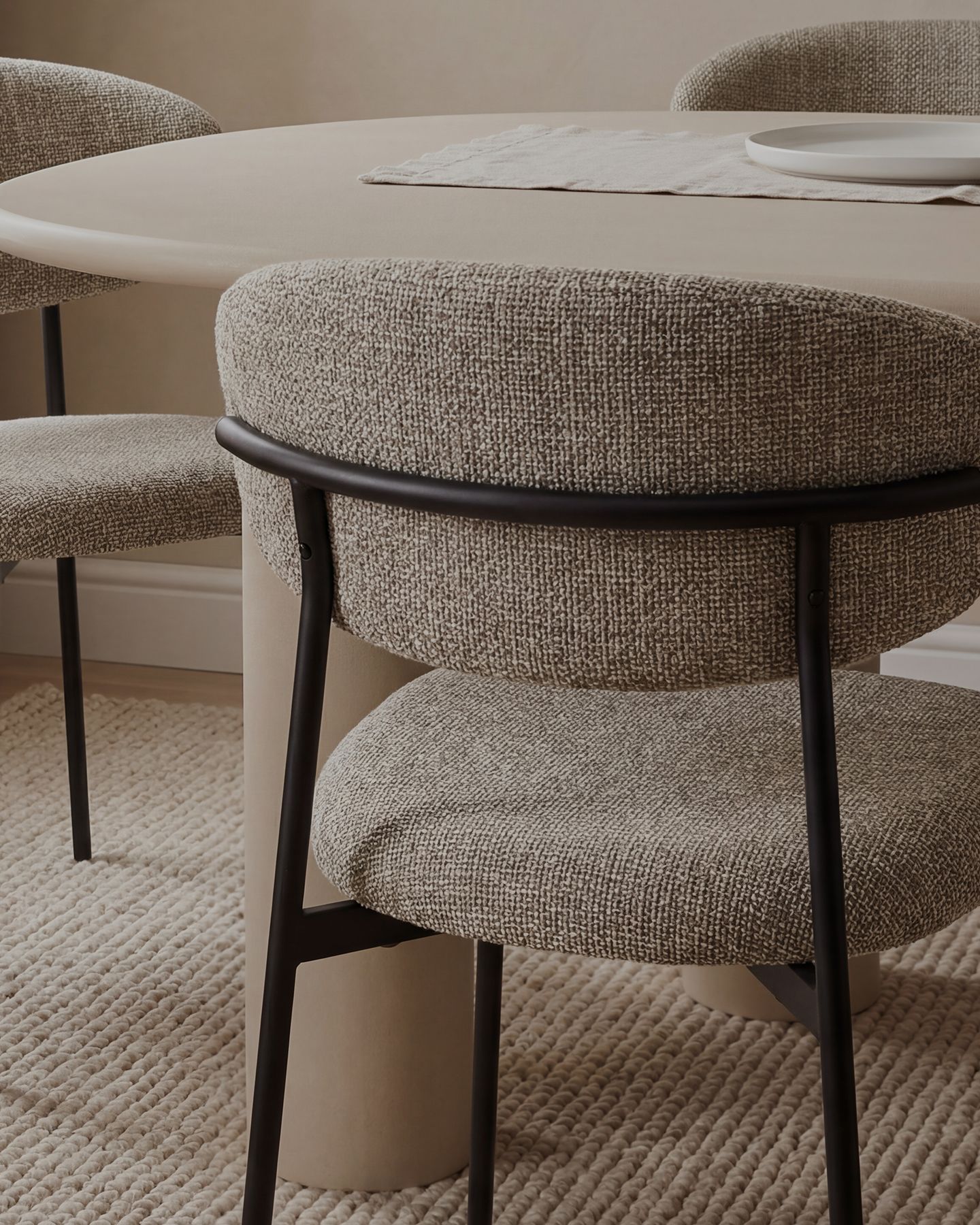 Best-sellers Micadoni — table ronde en chêne avec piètement cannelé et chaises effet velours, intérieur chaleureux.