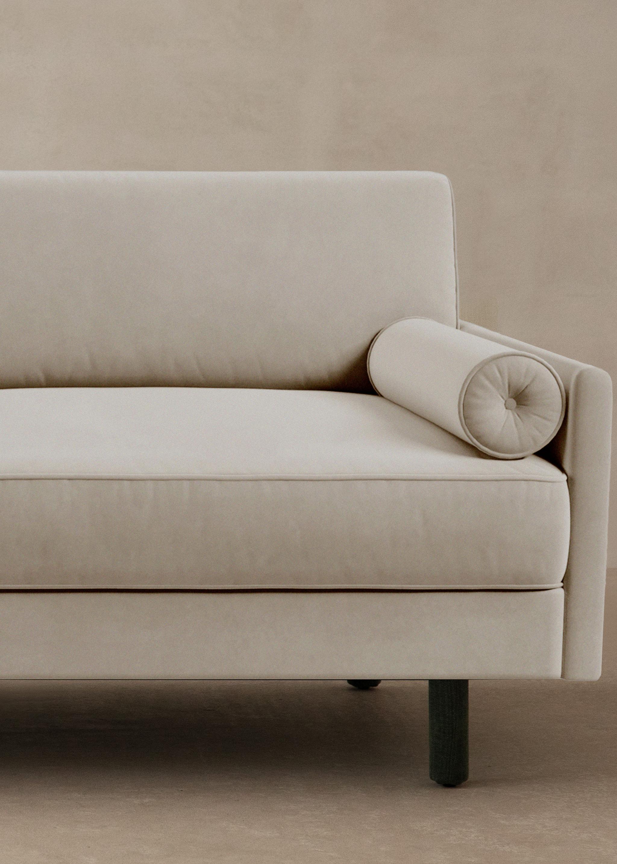 Canapé Scott en velours beige clair avec coussin rouleau et accoudoir fin – mobilier Micadoni