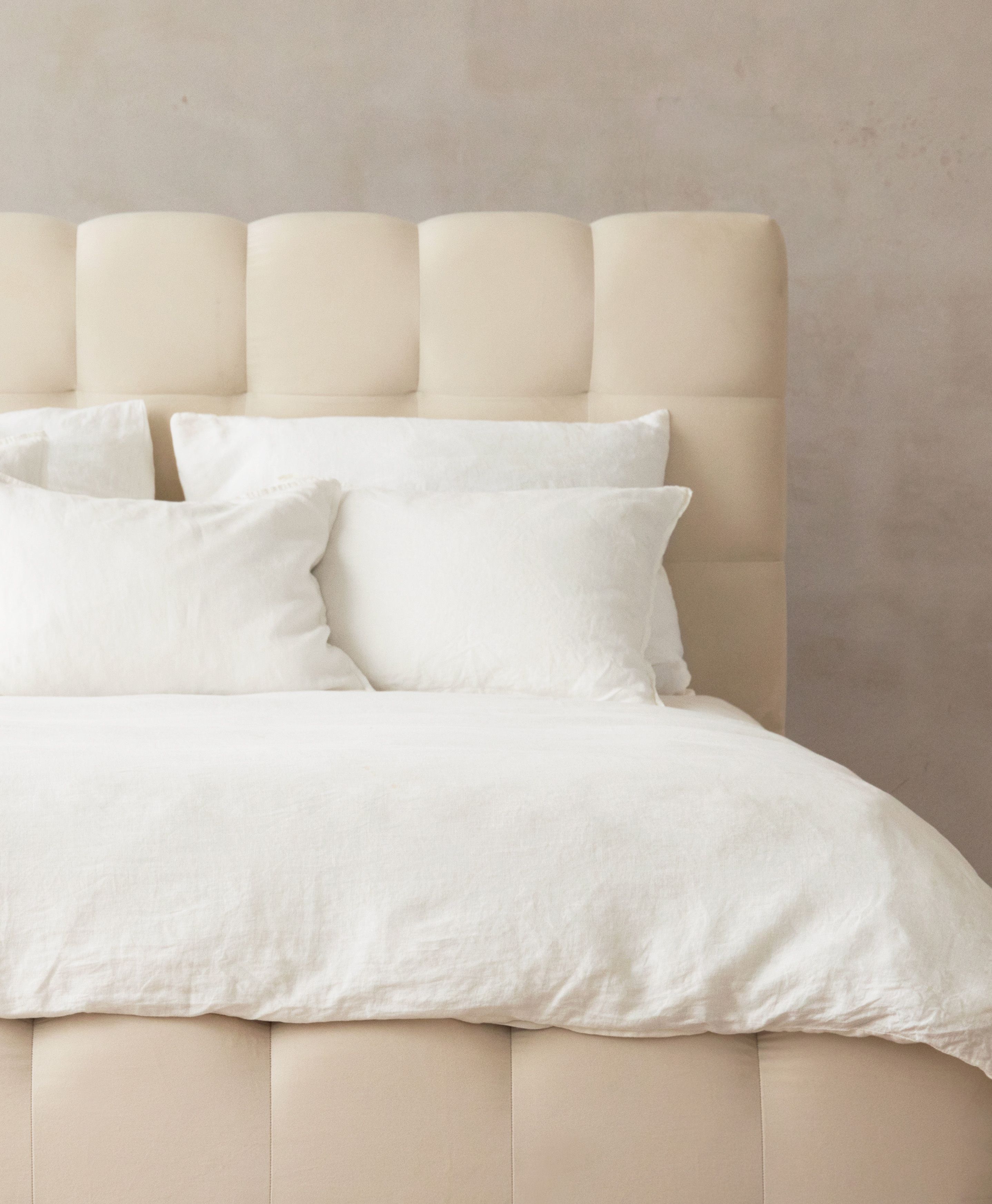 Gros plan du lit Mamaia en velours beige clair avec tête de lit arrondie et rembourrée – mobilier de chambre Micadoni