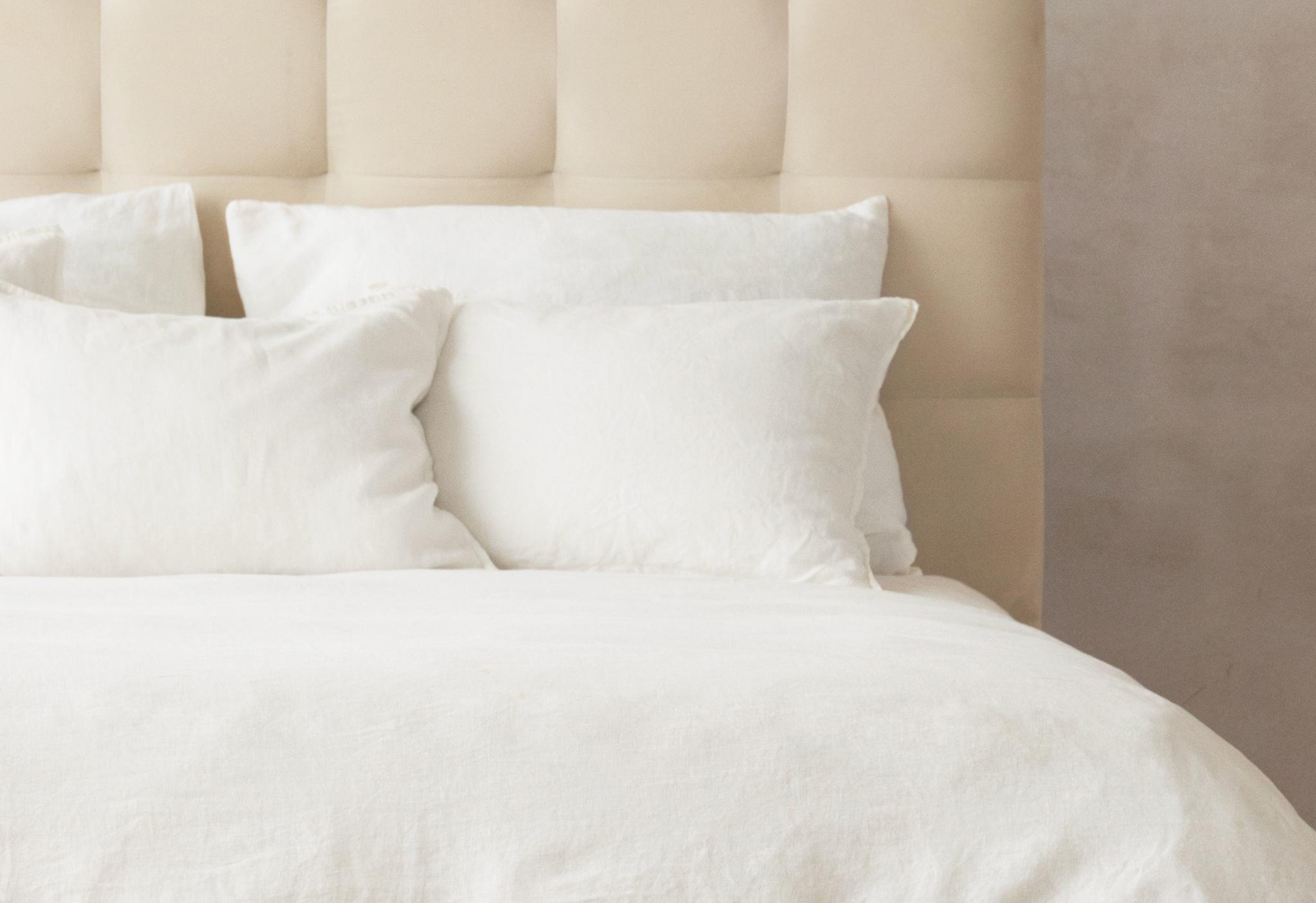 Gros plan du lit Mamaia en velours beige clair avec tête de lit arrondie et rembourrée – mobilier de chambre Micadoni