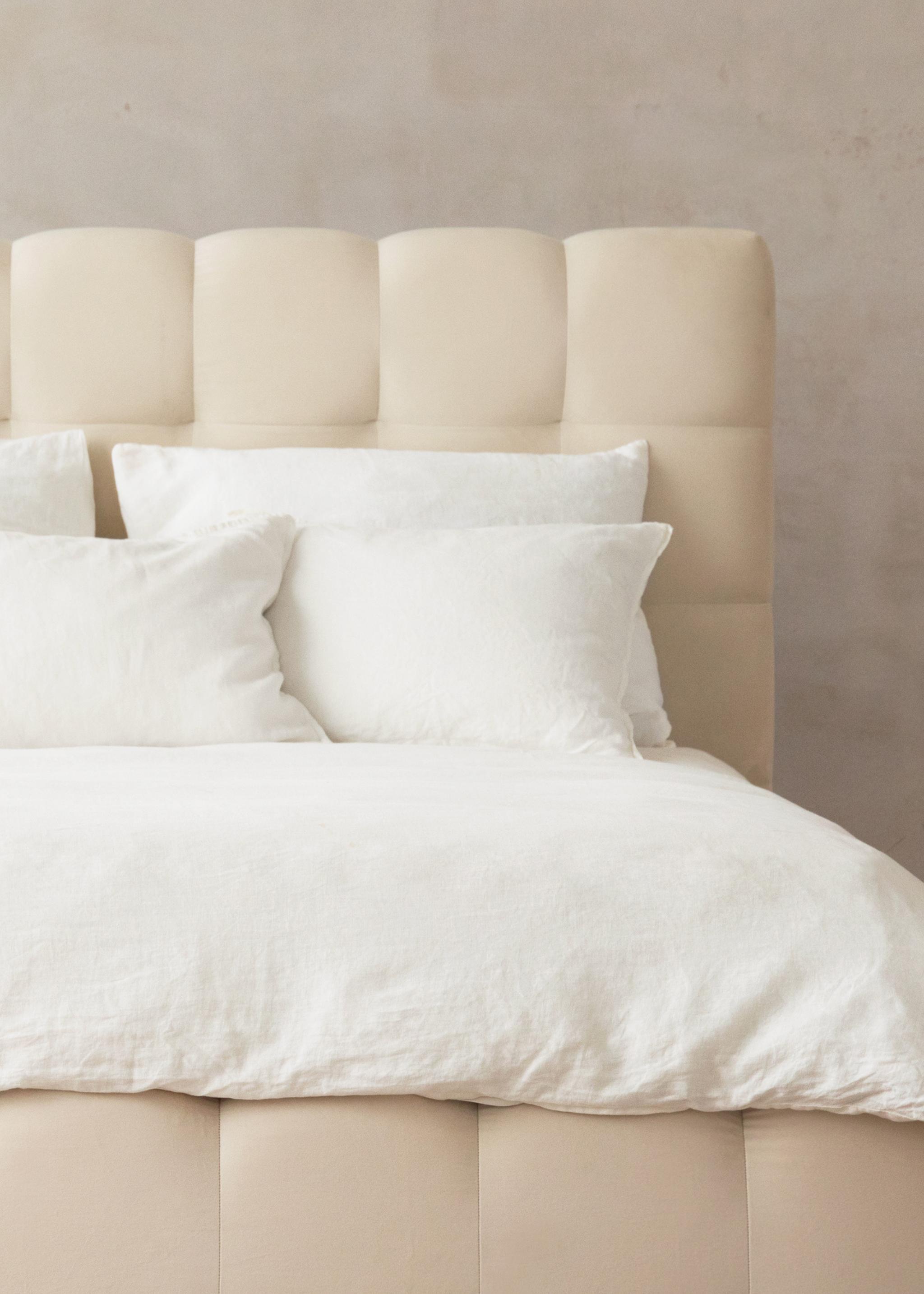 Gros plan du lit Mamaia en velours beige clair avec tête de lit arrondie et rembourrée – mobilier de chambre Micadoni