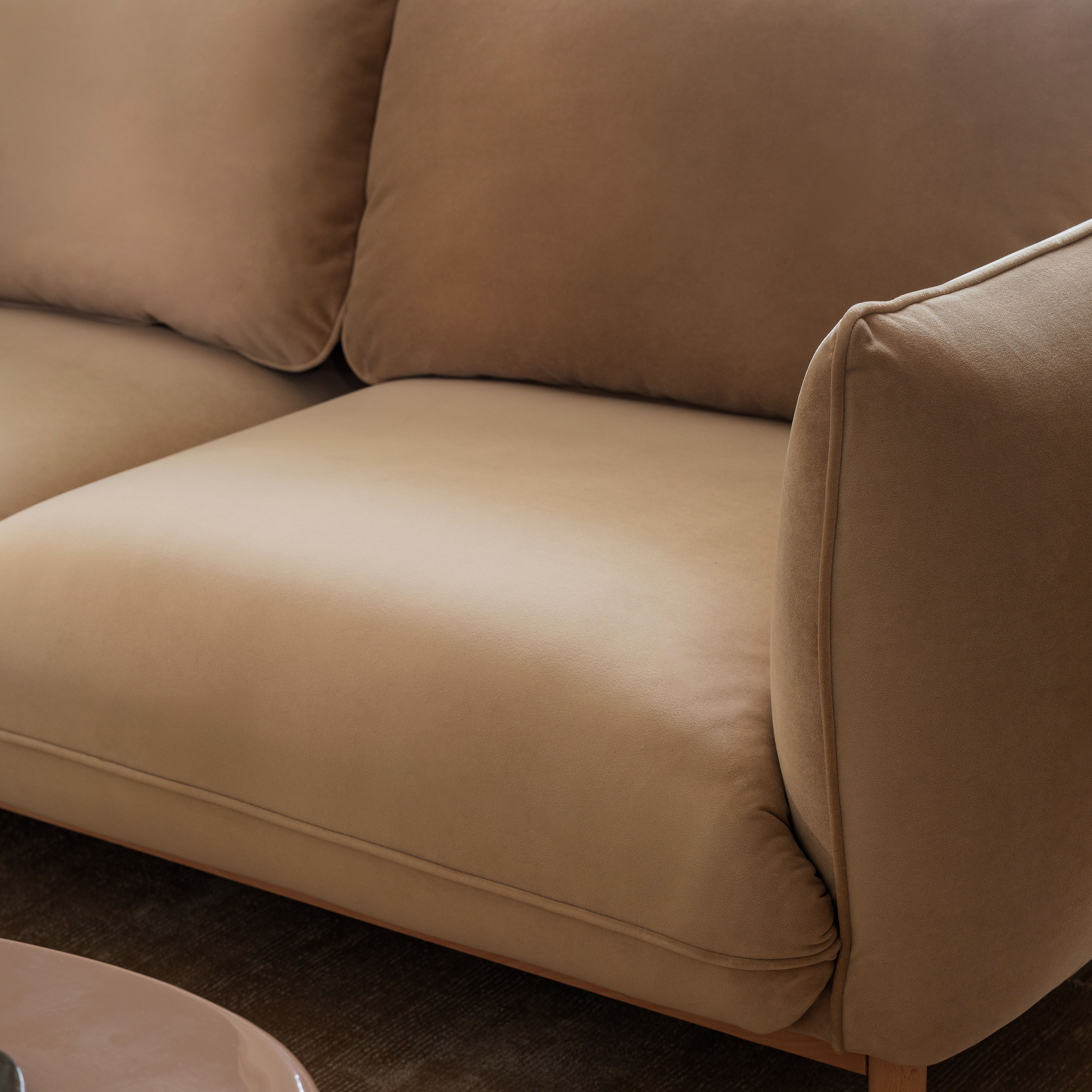 Canapés Micadoni – gros plan d’un canapé vert olive avec coussin rond en bouclé, bougies allumées en arrière-plan.