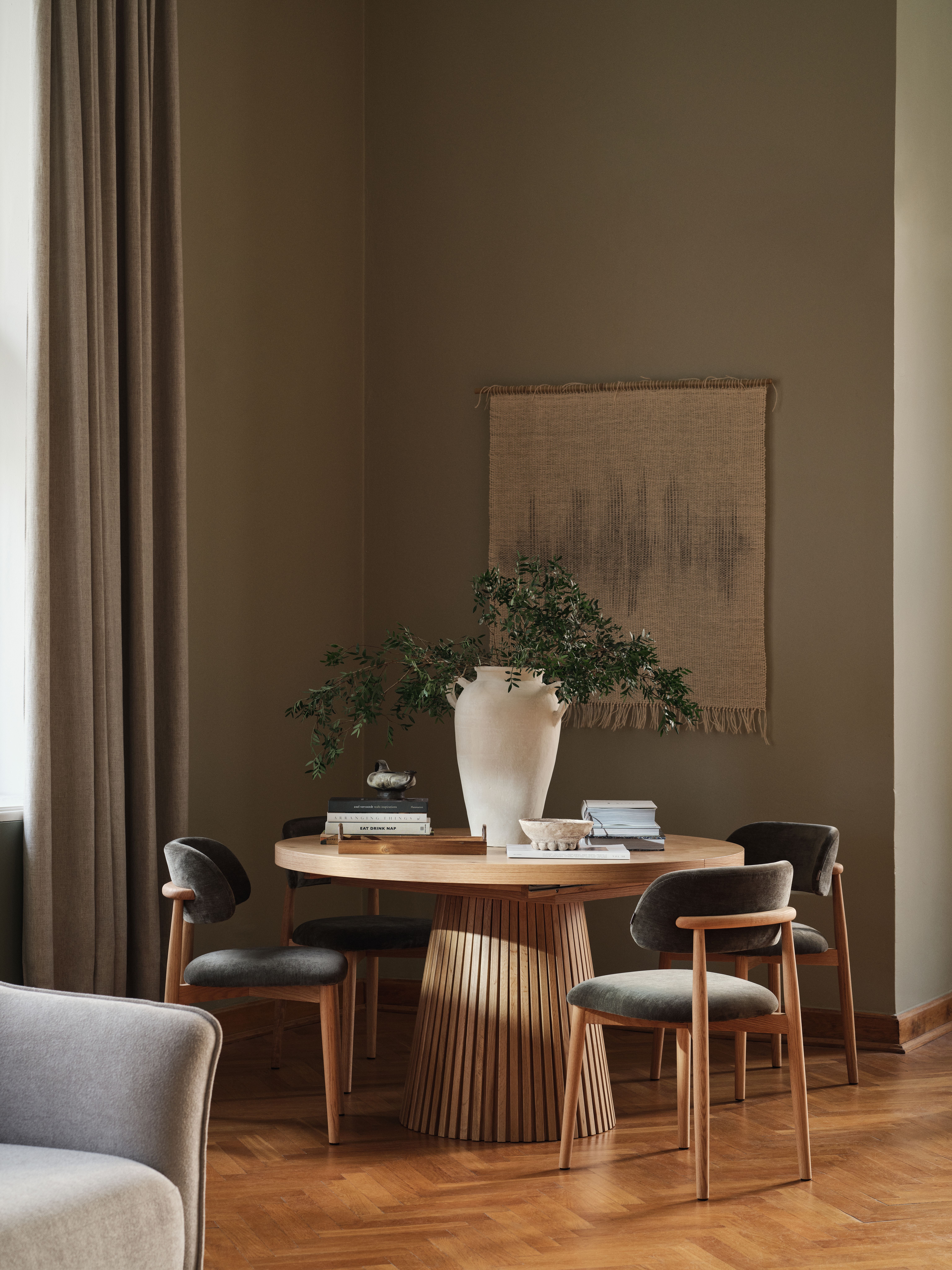 Table de salle à manger Micadoni Portmany avec chaises Sander en finition sombre, bords arrondis et tissu anthracite dans une salle à manger douce et lumineuse.