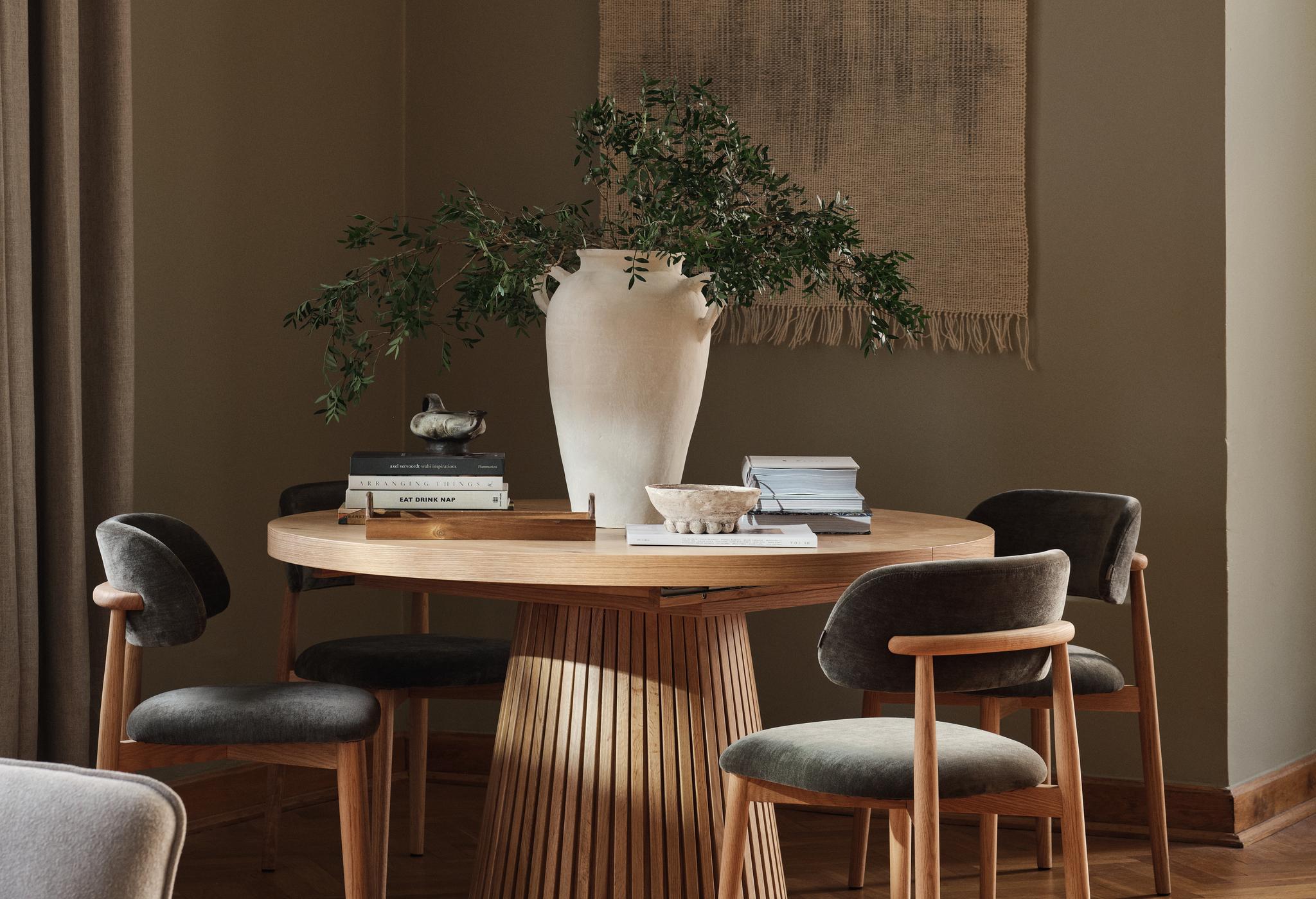 Table de salle à manger Micadoni Portmany avec chaises Sander en finition sombre, bords arrondis et tissu anthracite dans une salle à manger douce et lumineuse.
