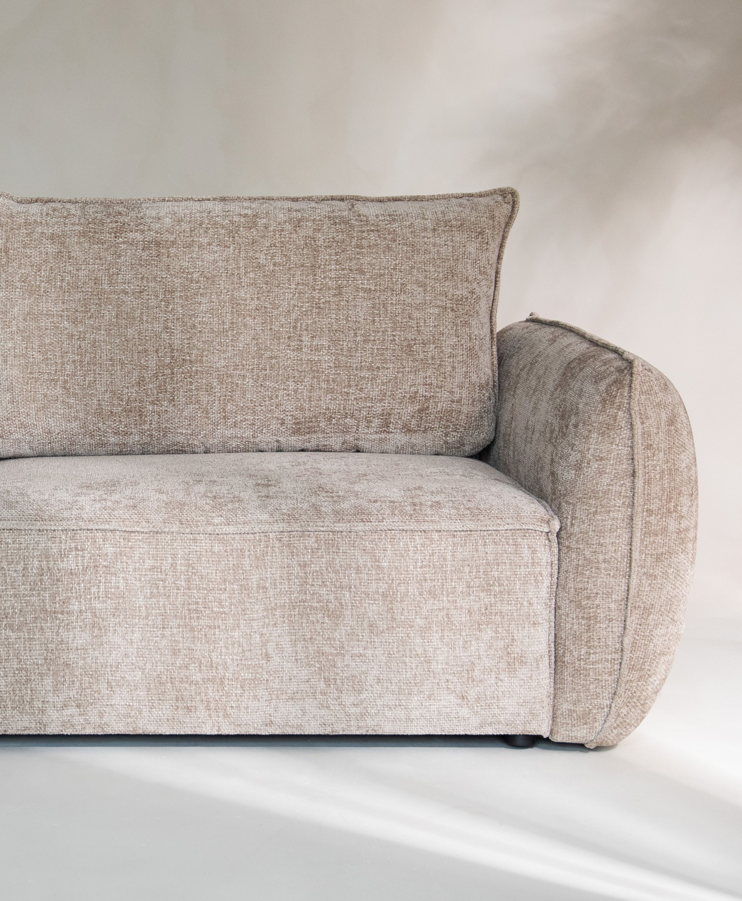 Gros plan du canapé Kaelle en tissu texturé beige avec accoudoir arrondi et assise profonde – mobilier Micadoni