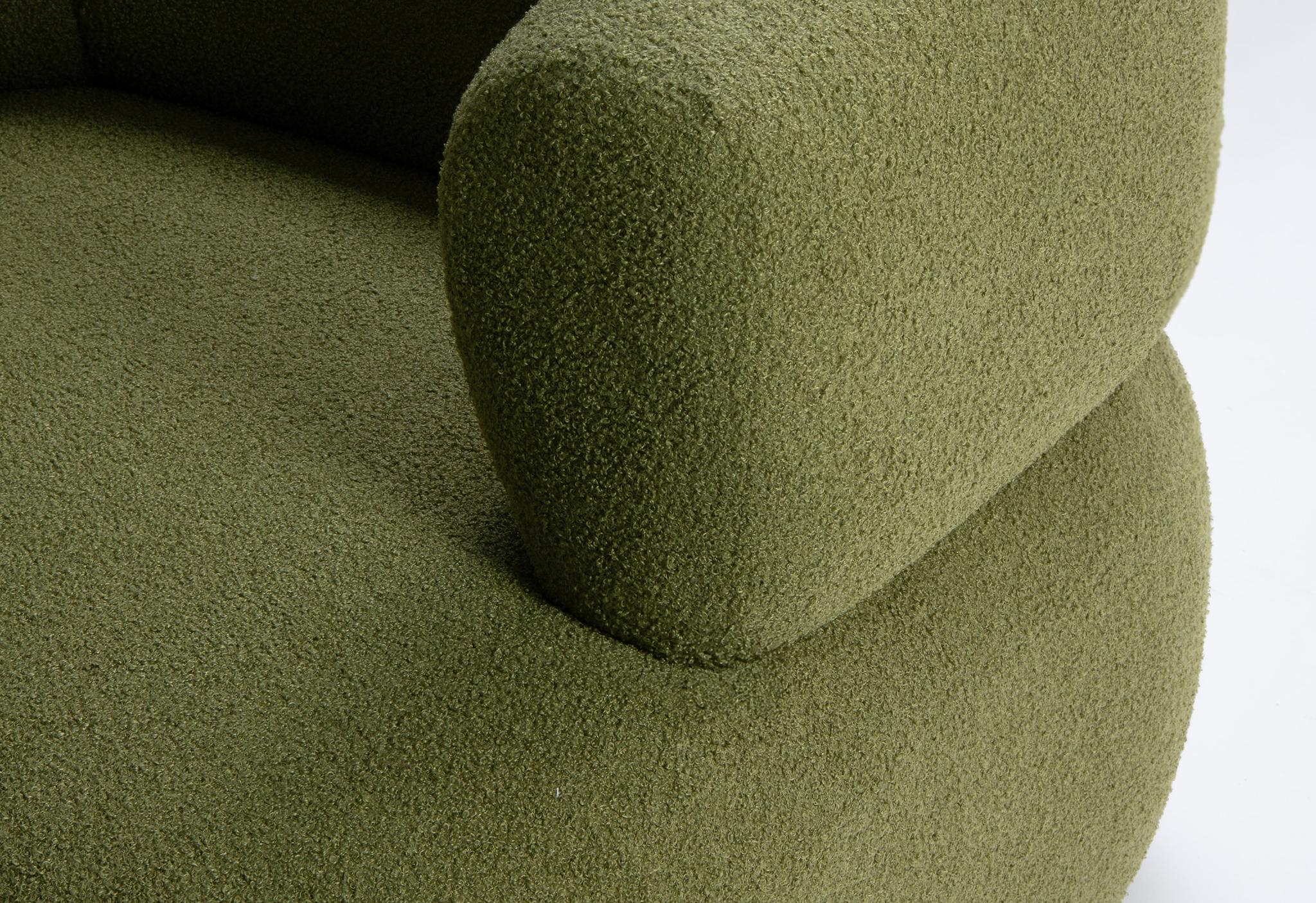 Gros plan du fauteuil Jenny en bouclé vert avec dossier arrondi et accoudoir sculpté – mobilier Micadoni