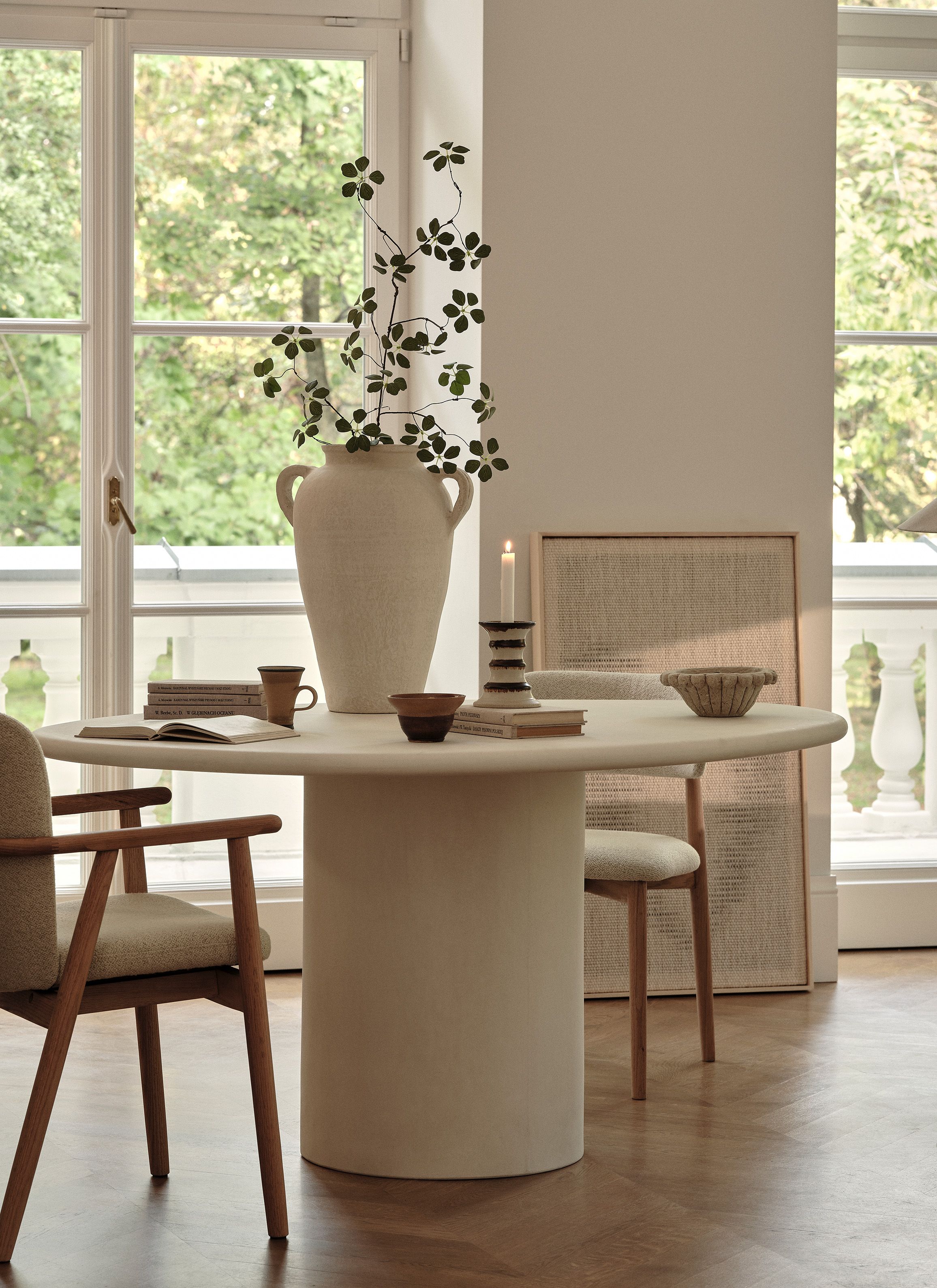 able de salle à manger ronde Micadoni Daria avec chaises Ria, pièce lumineuse, piètement colonne et détails chêne.