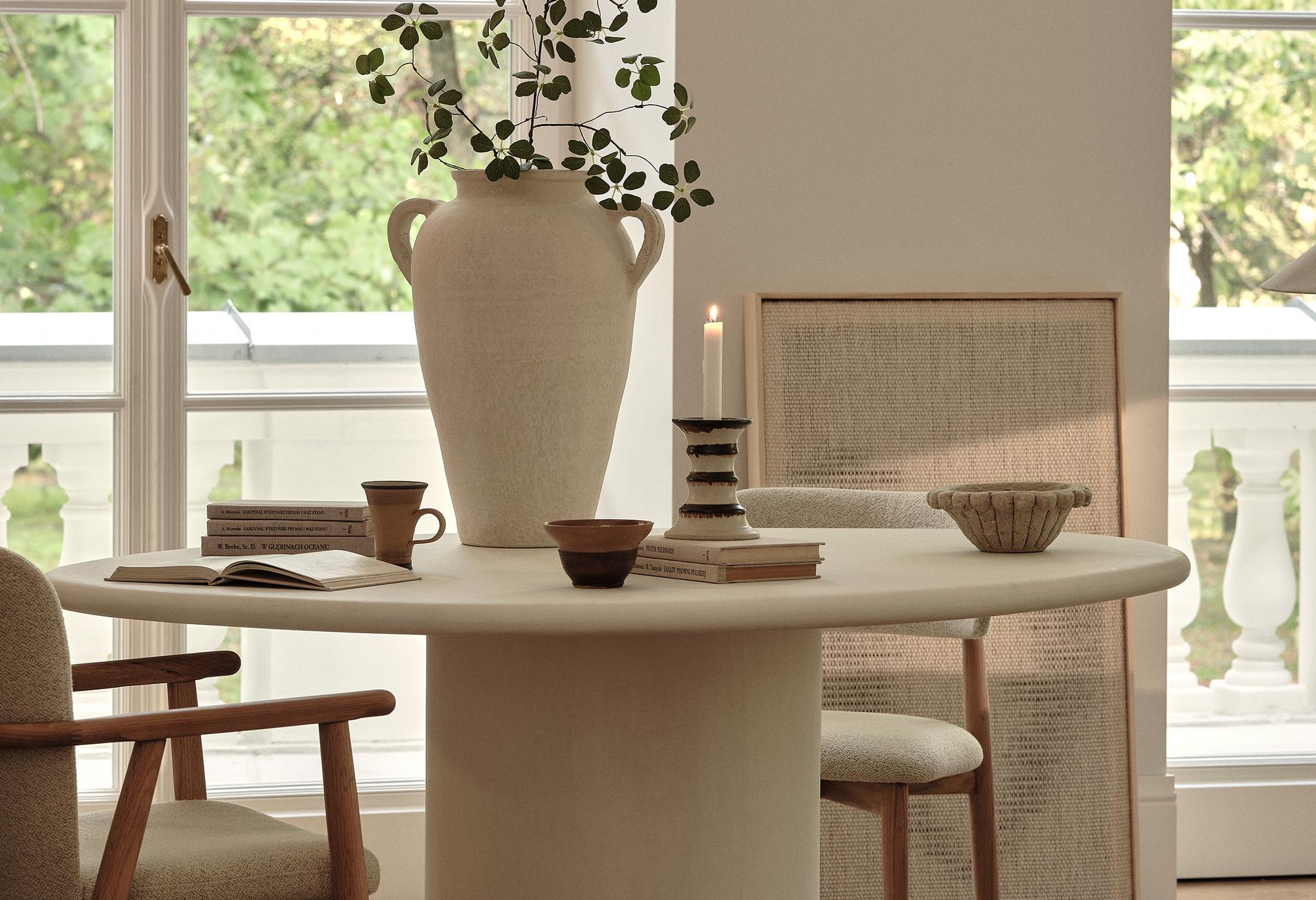 able de salle à manger ronde Micadoni Daria avec chaises Ria, pièce lumineuse, piètement colonne et détails chêne.