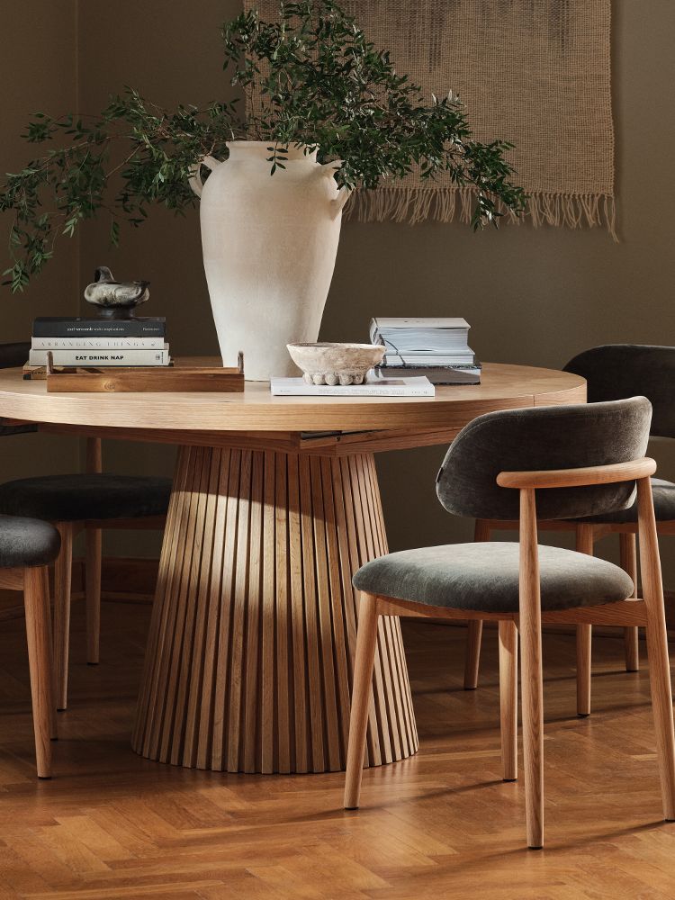 Lit Micadoni avec tête de lit capitonnée et encadrement en bois arrondi, linge de lit blanc, lumière douce.