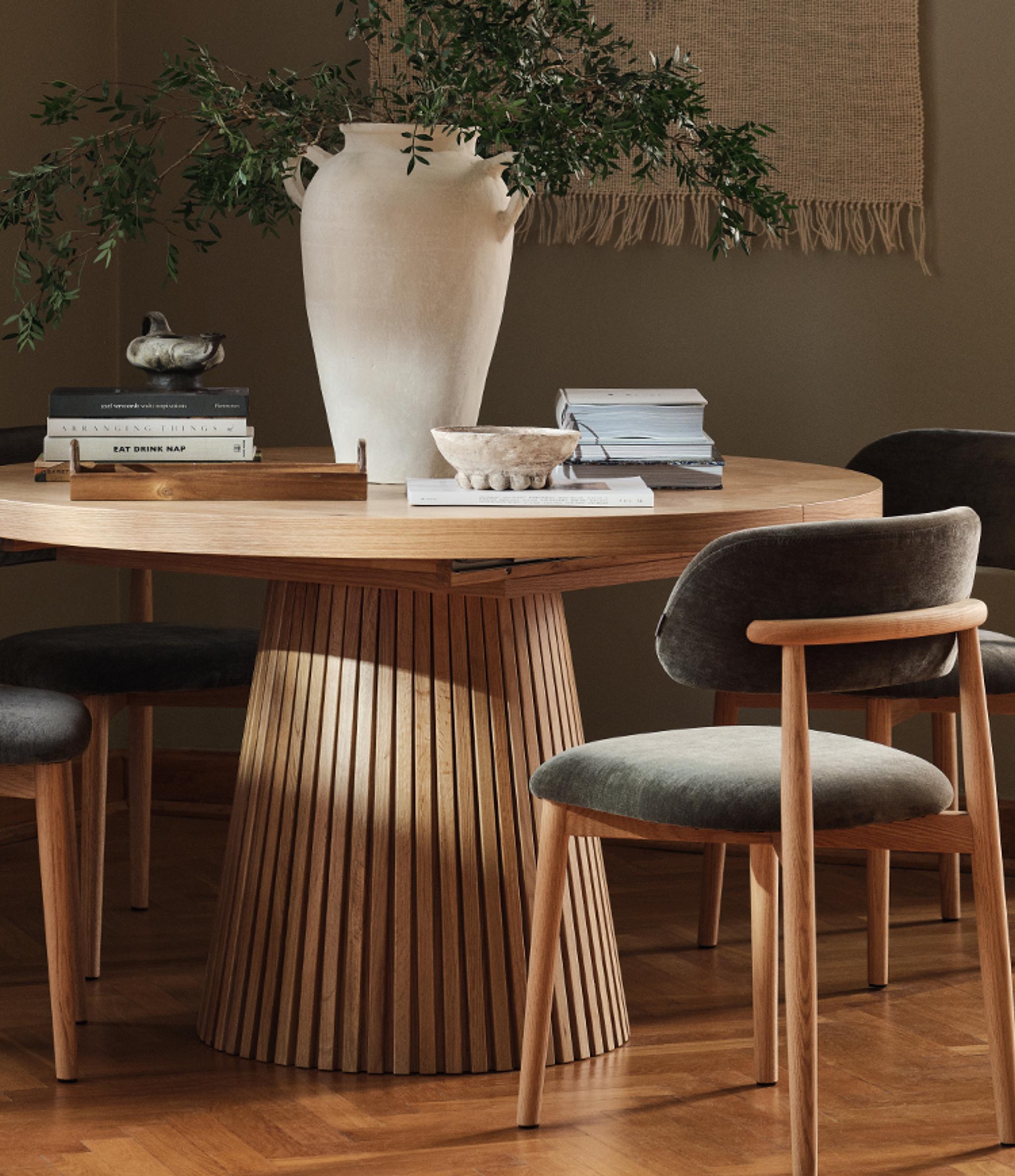 Lit Micadoni avec tête de lit capitonnée et encadrement en bois arrondi, linge de lit blanc, lumière douce.