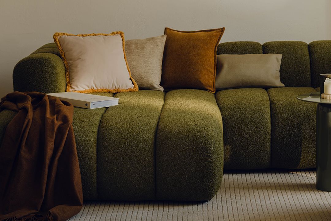 Gros plan du canapé modulaire Lupine en tissu crème avec surpiqûres verticales et courbes sculpturales – mobilier Micadoni