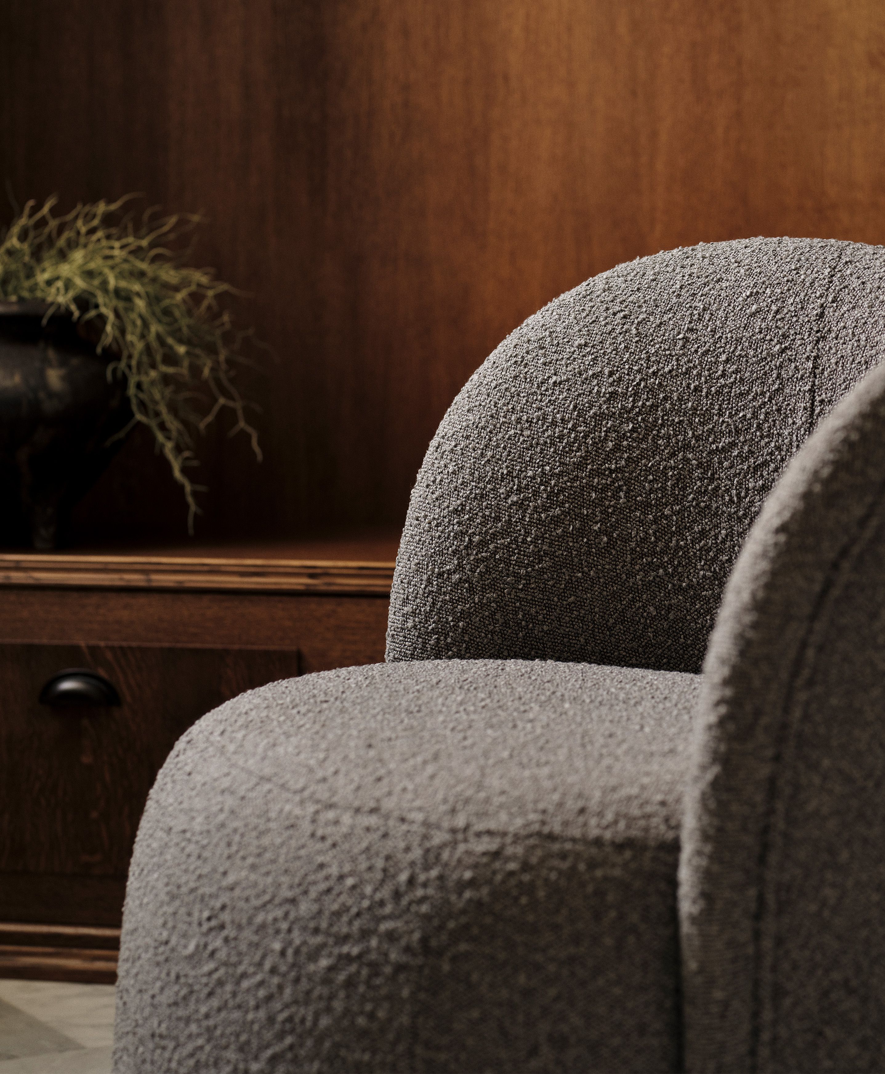 Gros plan du fauteuil Saamit en tissu bouclé gris avec dossier arrondi – mobilier Micadoni