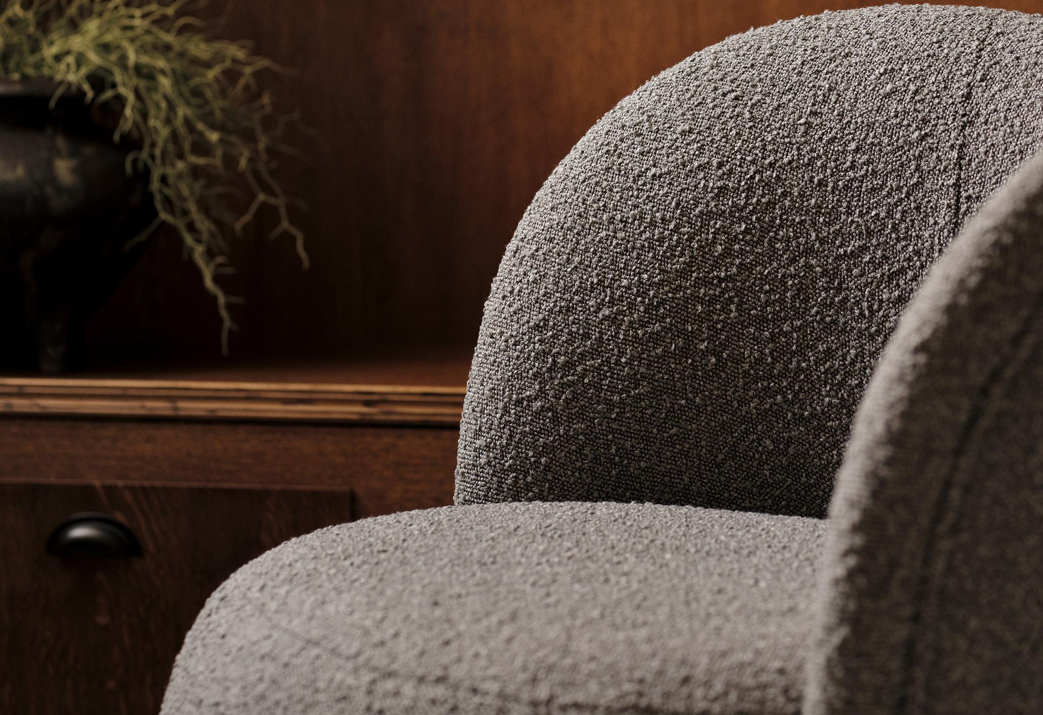 Gros plan du fauteuil Saamit en tissu bouclé gris avec dossier arrondi – mobilier Micadoni