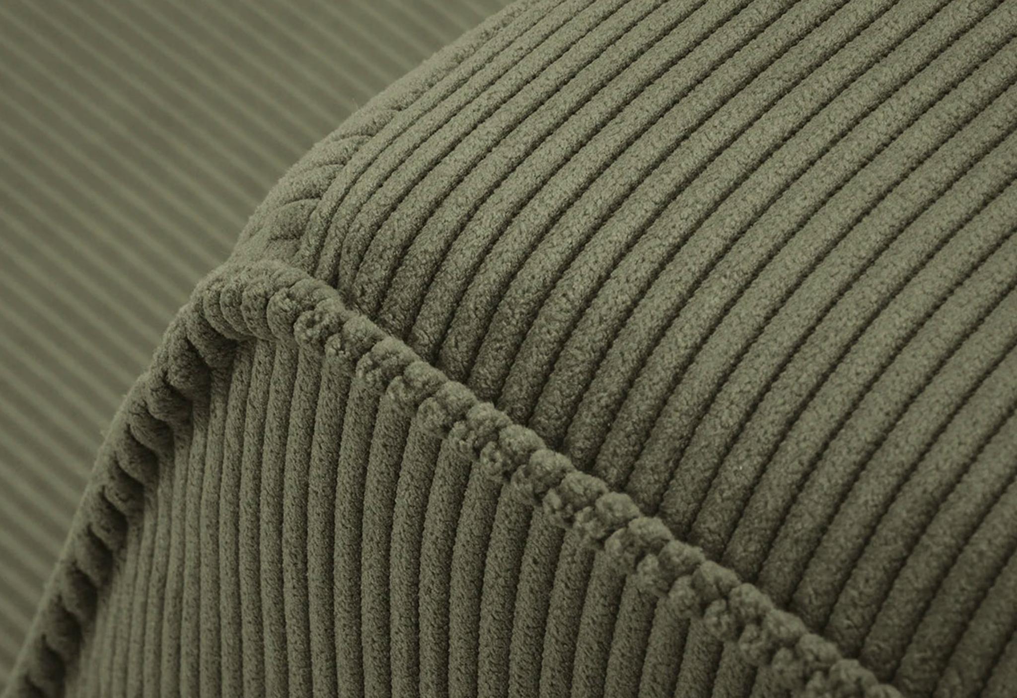 Gros plan du canapé Ruby en tissu côtelé vert olive avec coutures apparentes – mobilier Micadoni