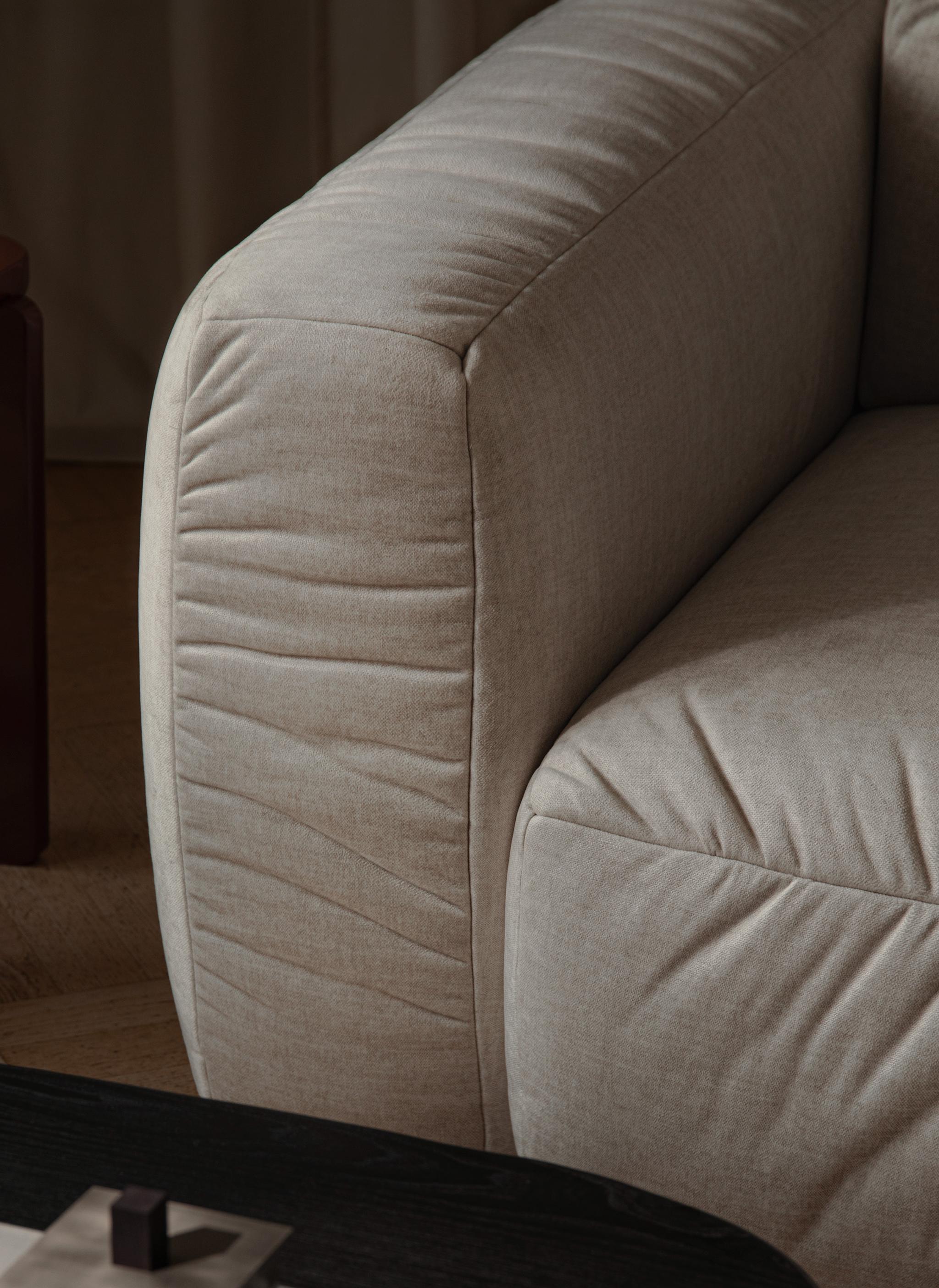 Gros plan sur le canapé Kate Micadoni, accoudoir arrondi et tissu jaune texturé sur sol neutre.