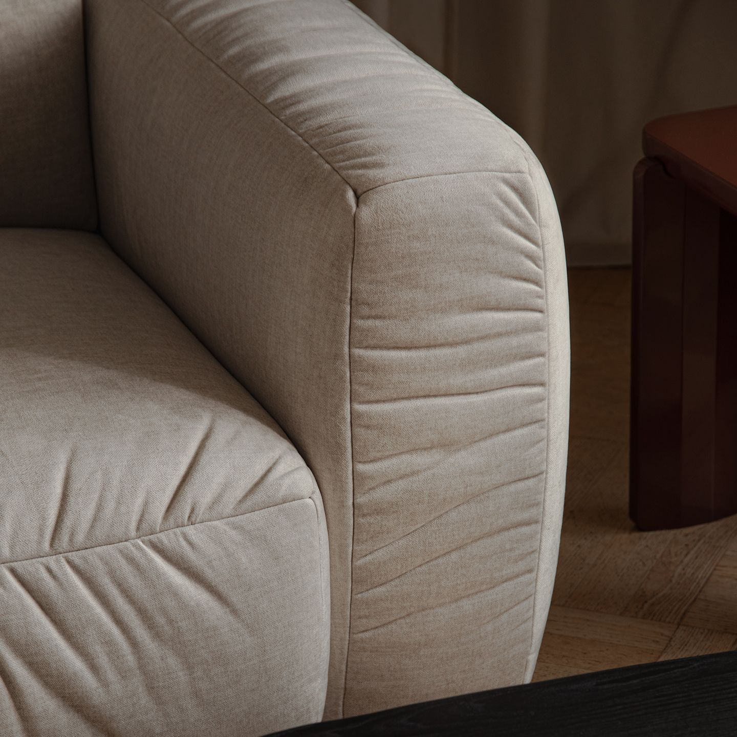 Gros plan sur un canapé Micadoni : accoudoir et dossier arrondis en tissu beige clair à tissage serré.