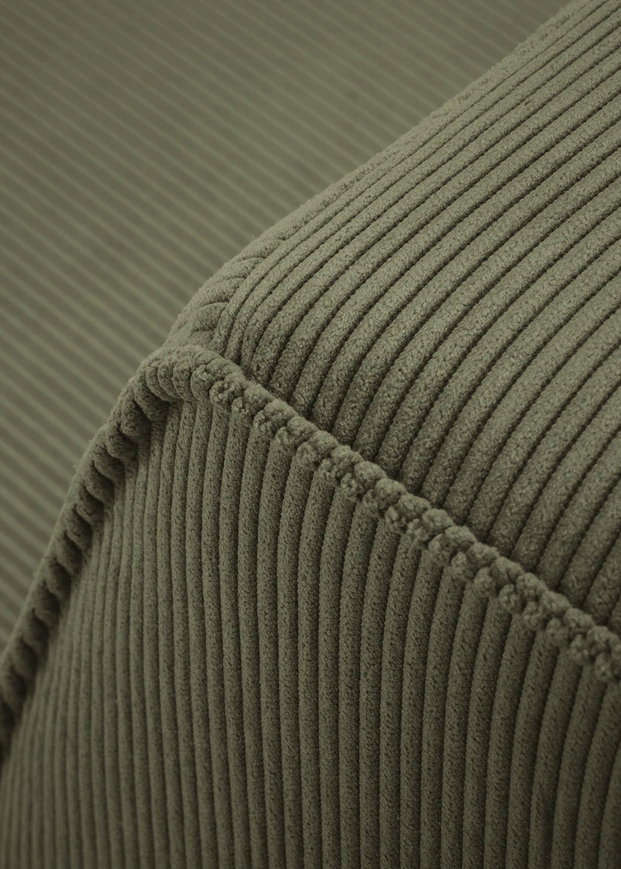 Gros plan du canapé Ruby en tissu côtelé vert olive avec coutures apparentes – mobilier Micadoni