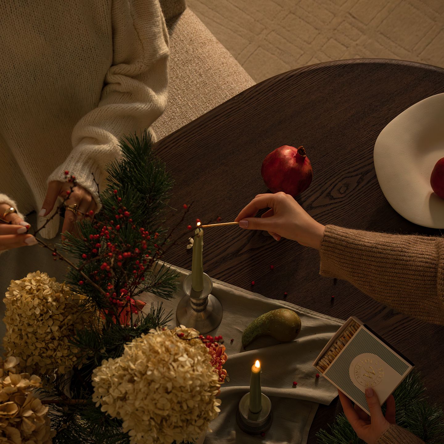 Table basse Micadoni avec bougie, grenades et livres.