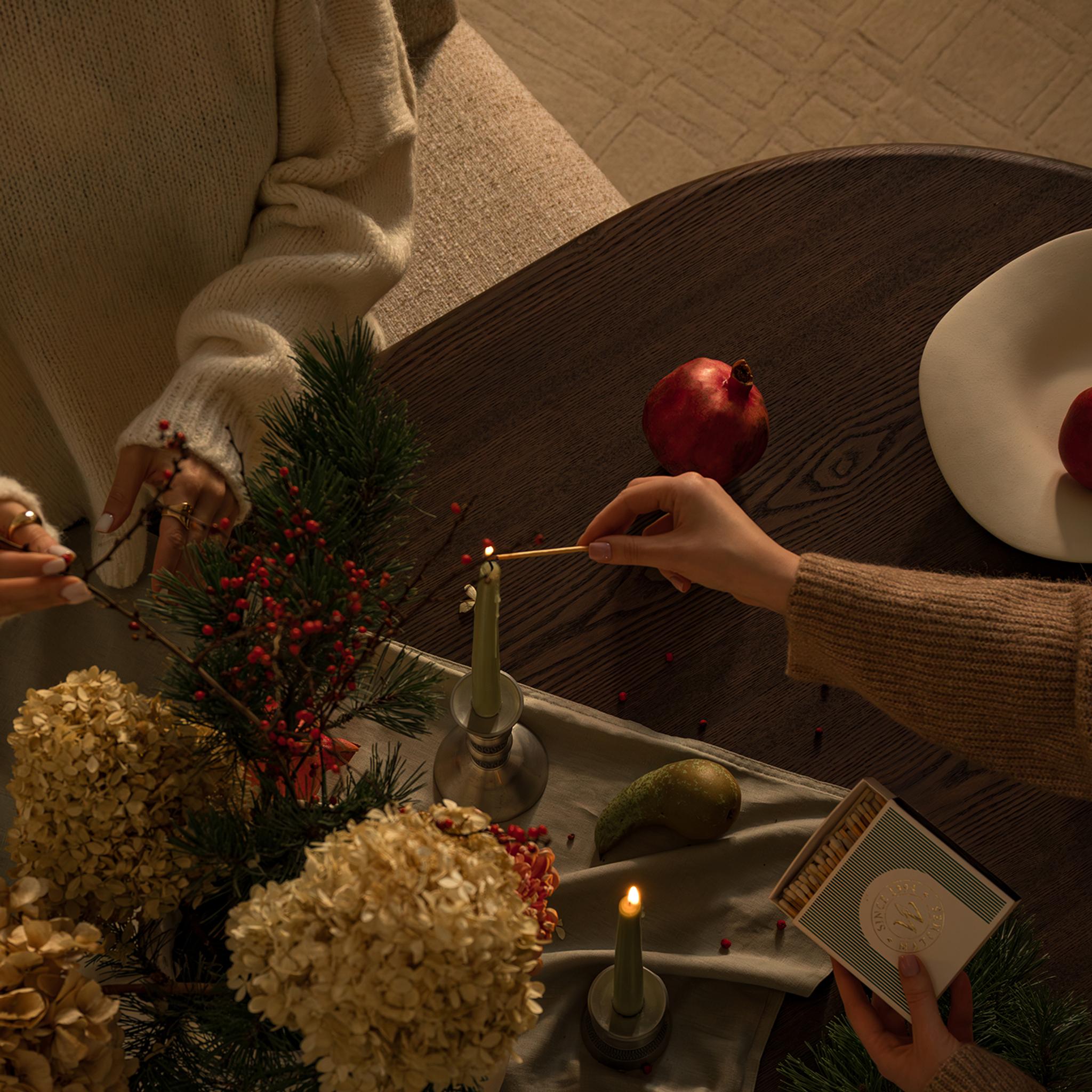 Table basse Micadoni avec bougie, grenades et livres.