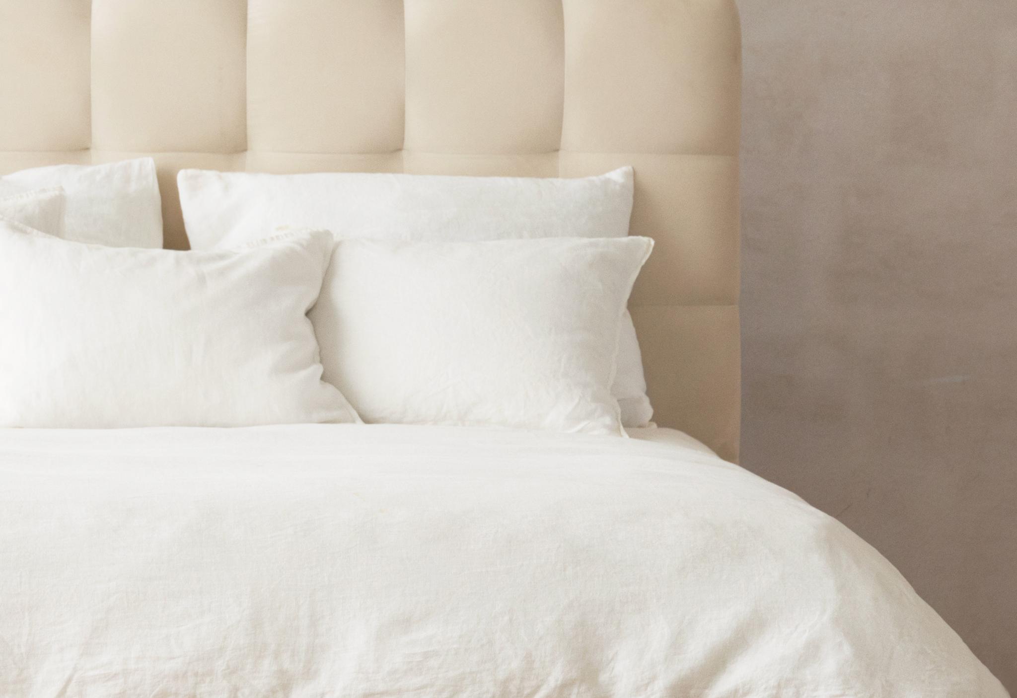 Gros plan du lit Mamaia en velours beige clair avec tête de lit arrondie et rembourrée – mobilier de chambre Micadoni