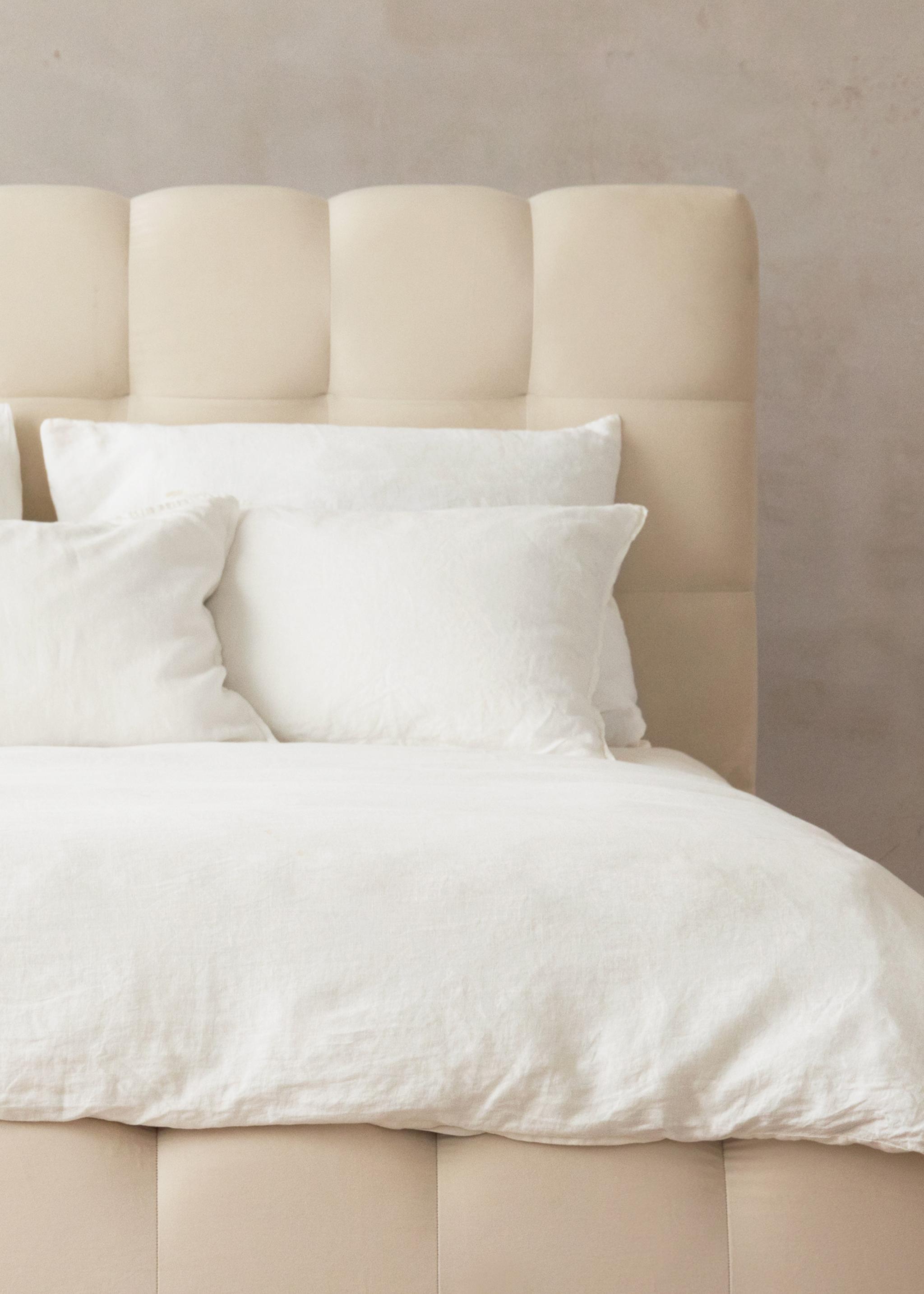 Gros plan du lit Mamaia en velours beige clair avec tête de lit arrondie et rembourrée – mobilier de chambre Micadoni