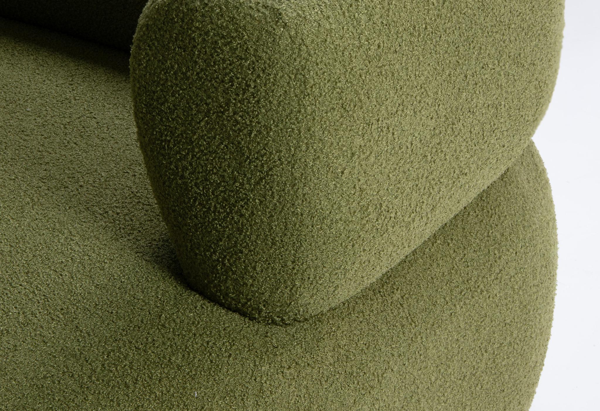 Gros plan du fauteuil Jenny en bouclé vert avec dossier arrondi et accoudoir sculpté – mobilier Micadoni