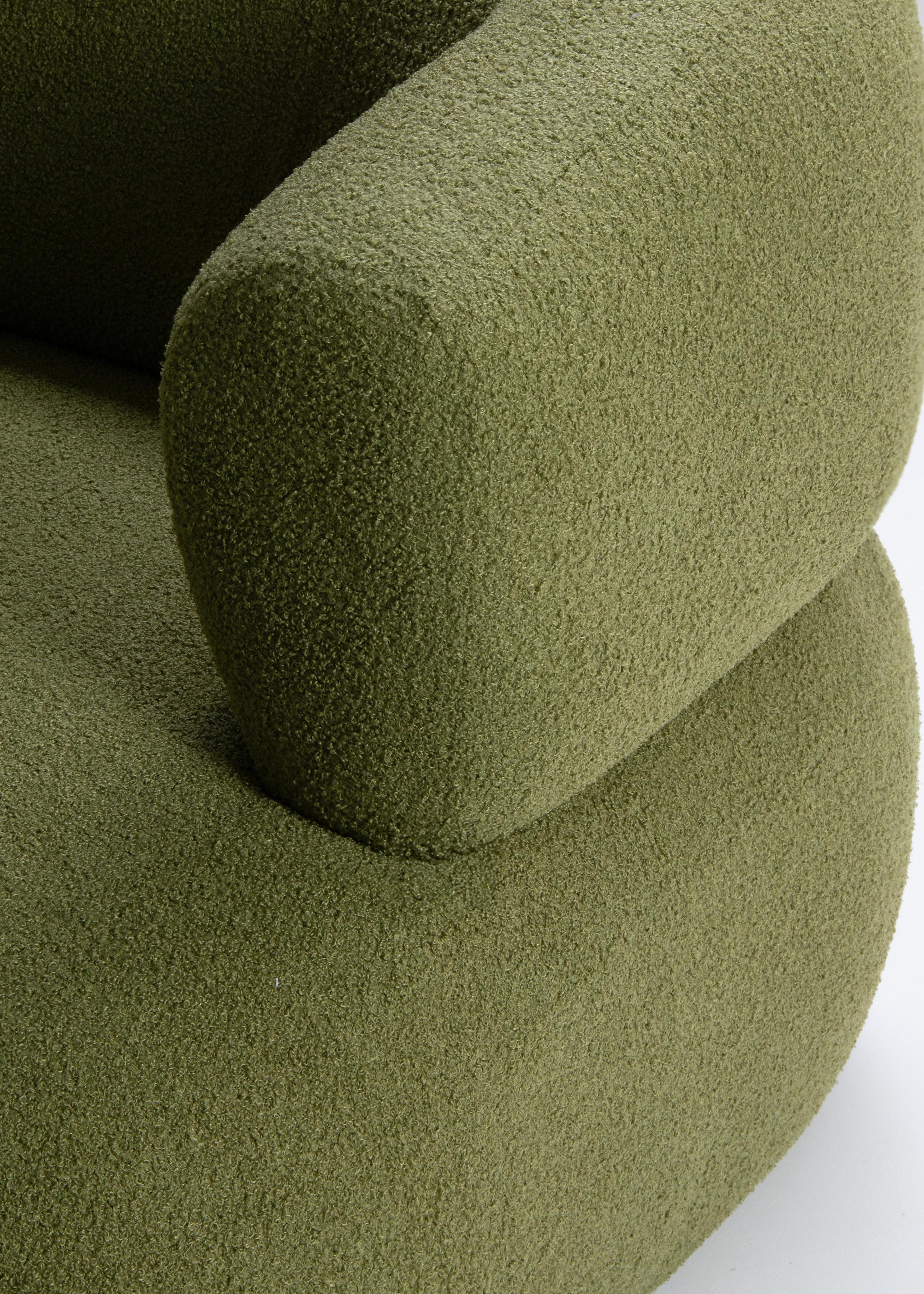 Gros plan du fauteuil Jenny en bouclé vert avec dossier arrondi et accoudoir sculpté – mobilier Micadoni