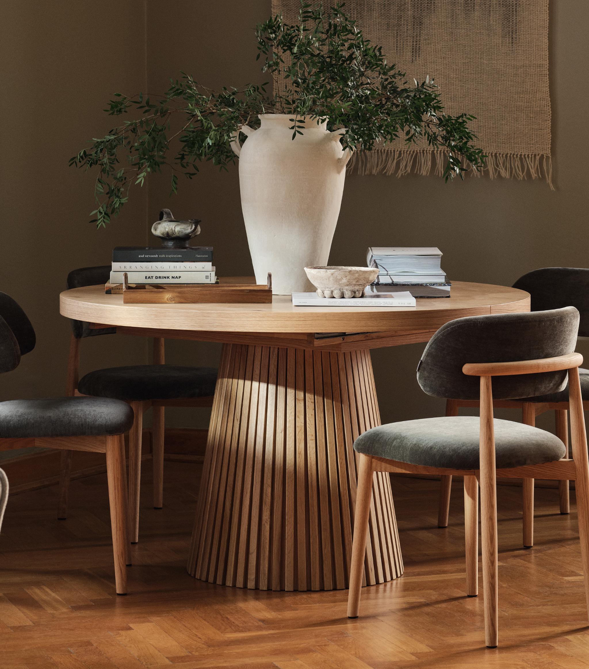 Lit Micadoni avec tête de lit capitonnée et encadrement en bois arrondi, linge de lit blanc, lumière douce.