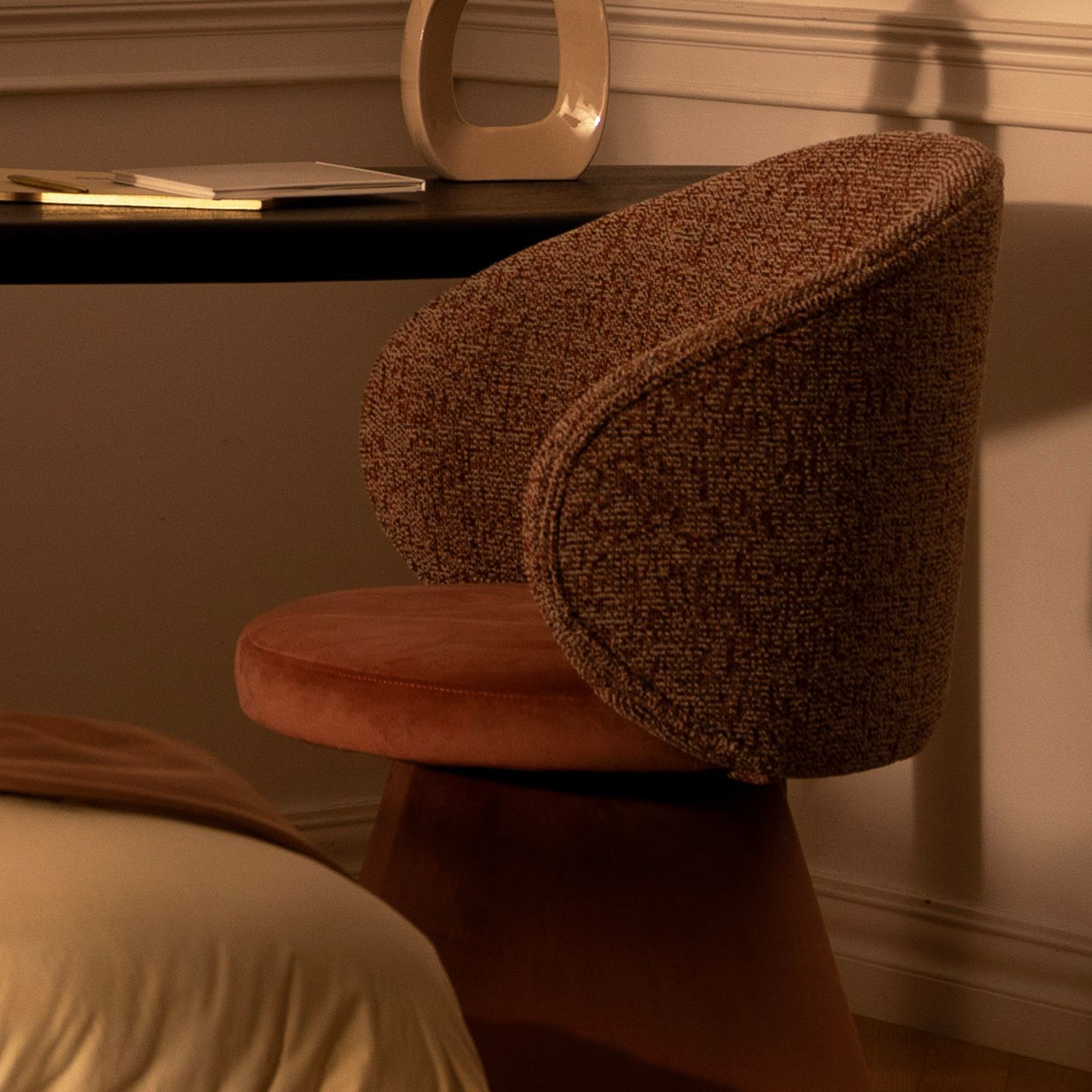 Chaises Micadoni – gros plan d’une chaise capitonnée au dossier courbé près d’un bureau.