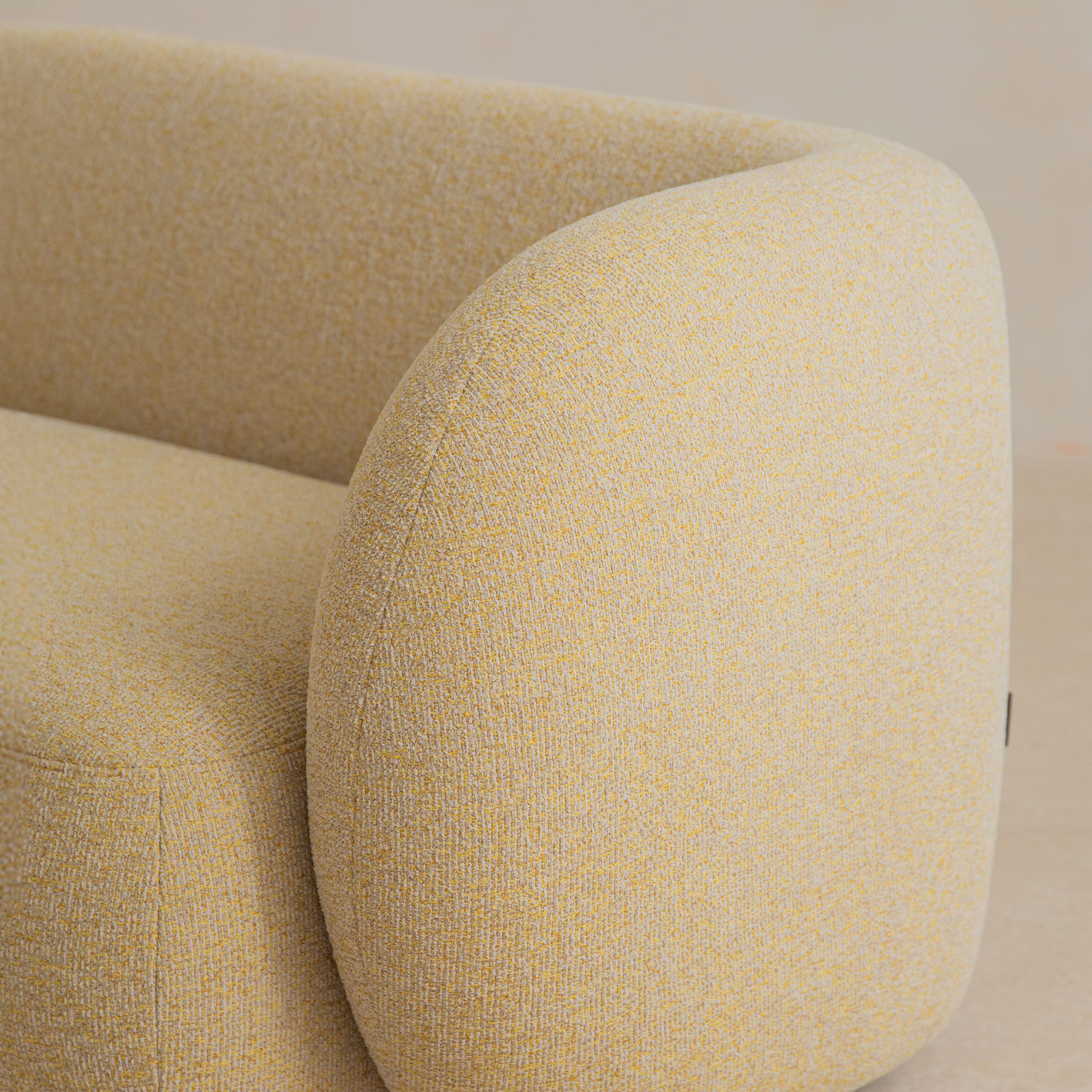Gros plan sur un canapé Micadoni : accoudoir et dossier arrondis en tissu beige clair à tissage serré.