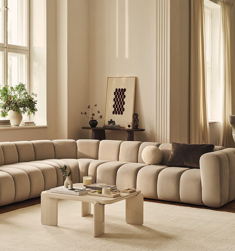 Lupine Modular Sofa in light beige velvet fabric next to white Jonc coffee table