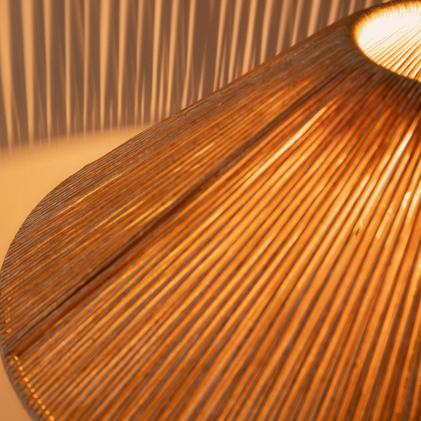 Lampes Micadoni – gros plan sur un abat-jour tressé projetant des ombres chaudes et linéaires.