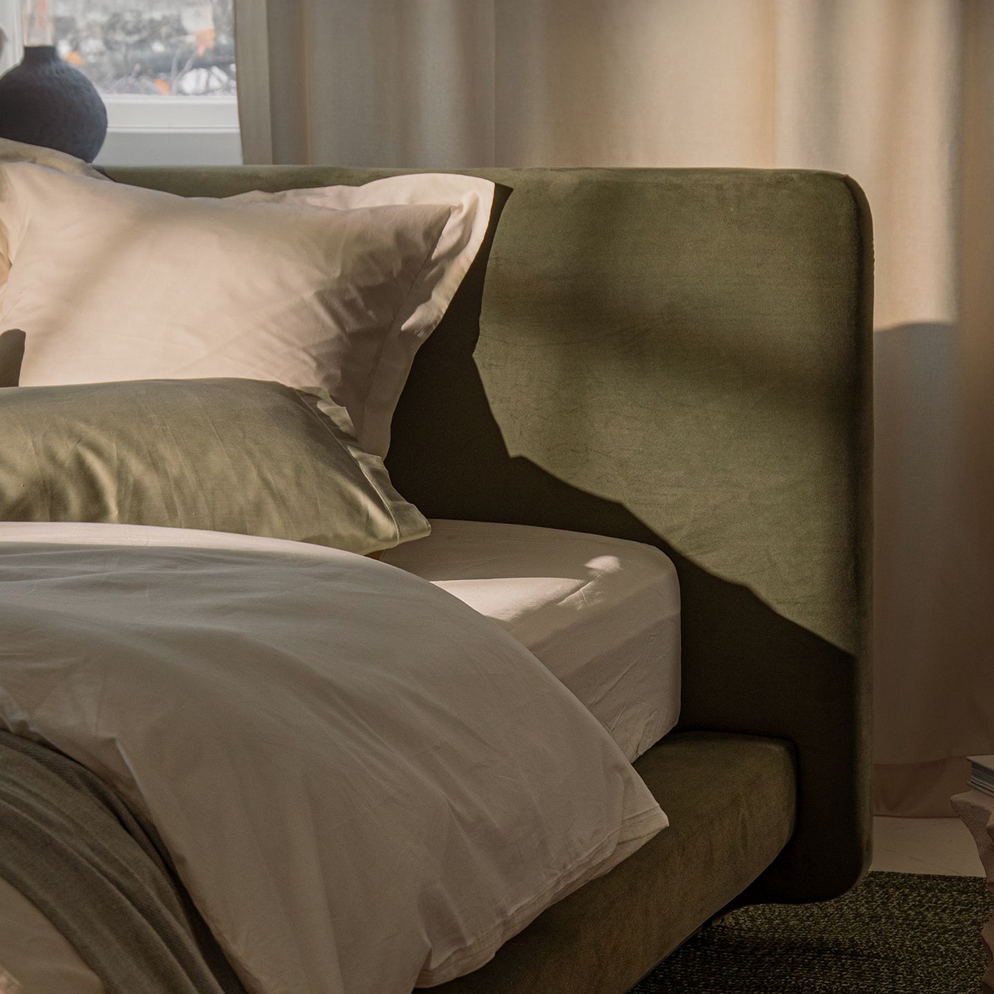 Lit Micadoni avec tête de lit capitonnée arrondie, éclairée par une lumière chaude de bougies.