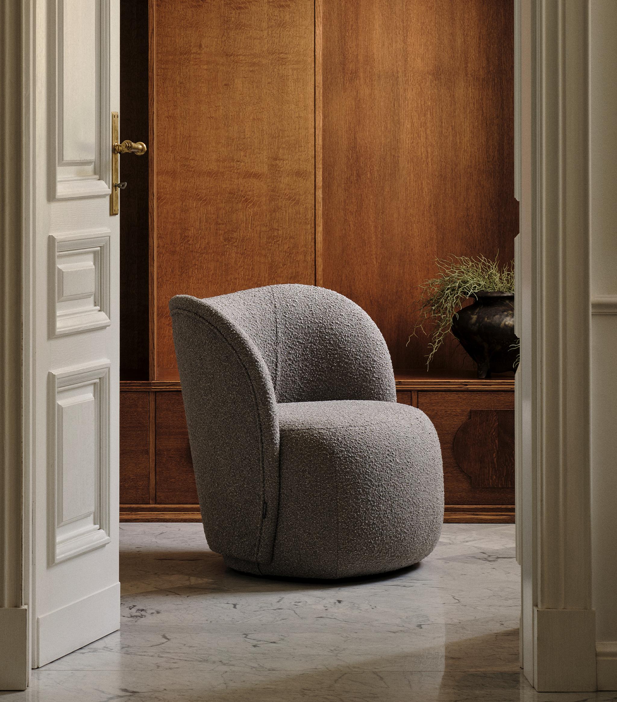 Fauteuil Micadoni aux lignes arrondies, revêtement texturé gris, mis en scène dans un intérieur chaleureux.