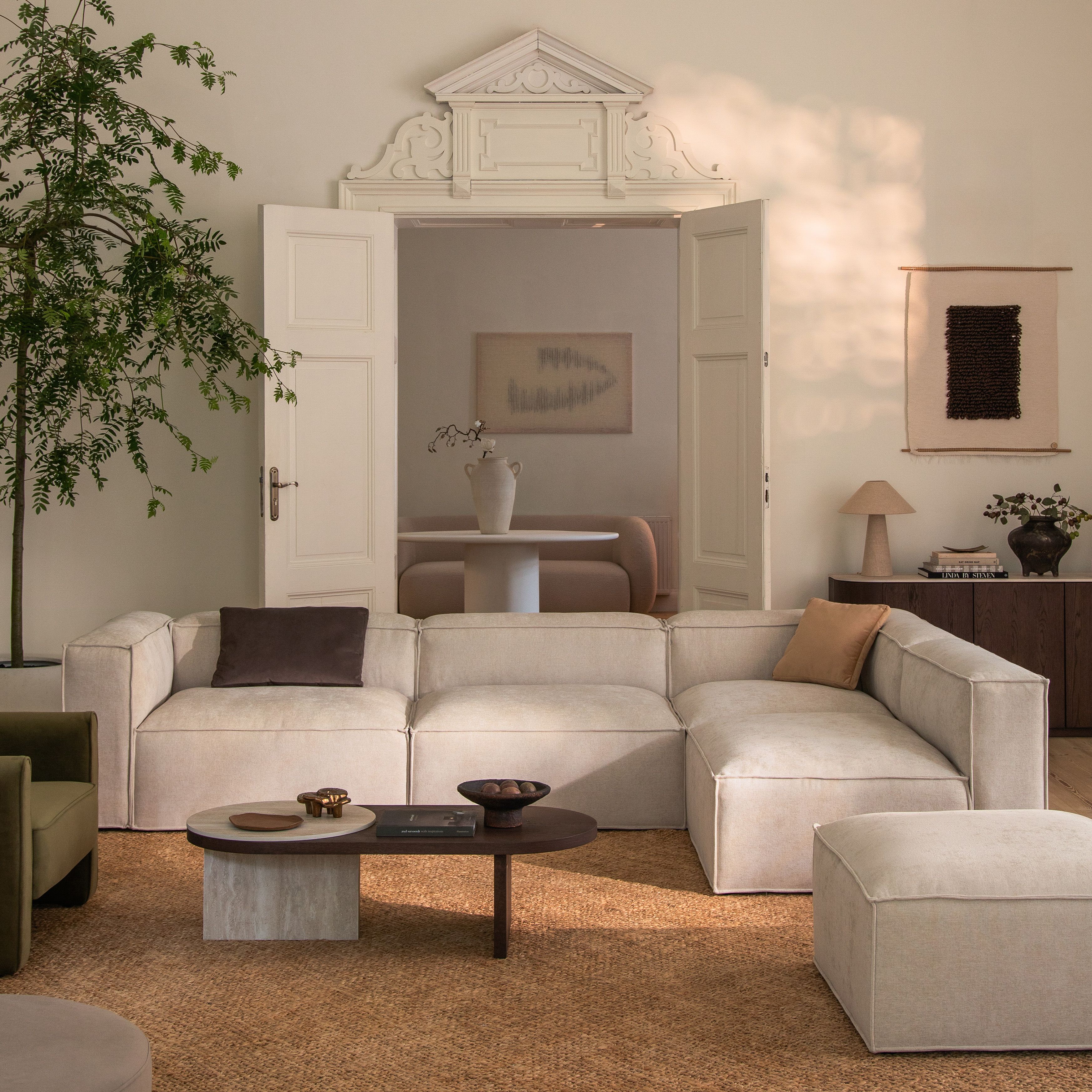 Canapé d’angle modulaire Nuria en tissu gris clair texturé avec accoudoirs droits et coussins assortis – mobilier Micadoni