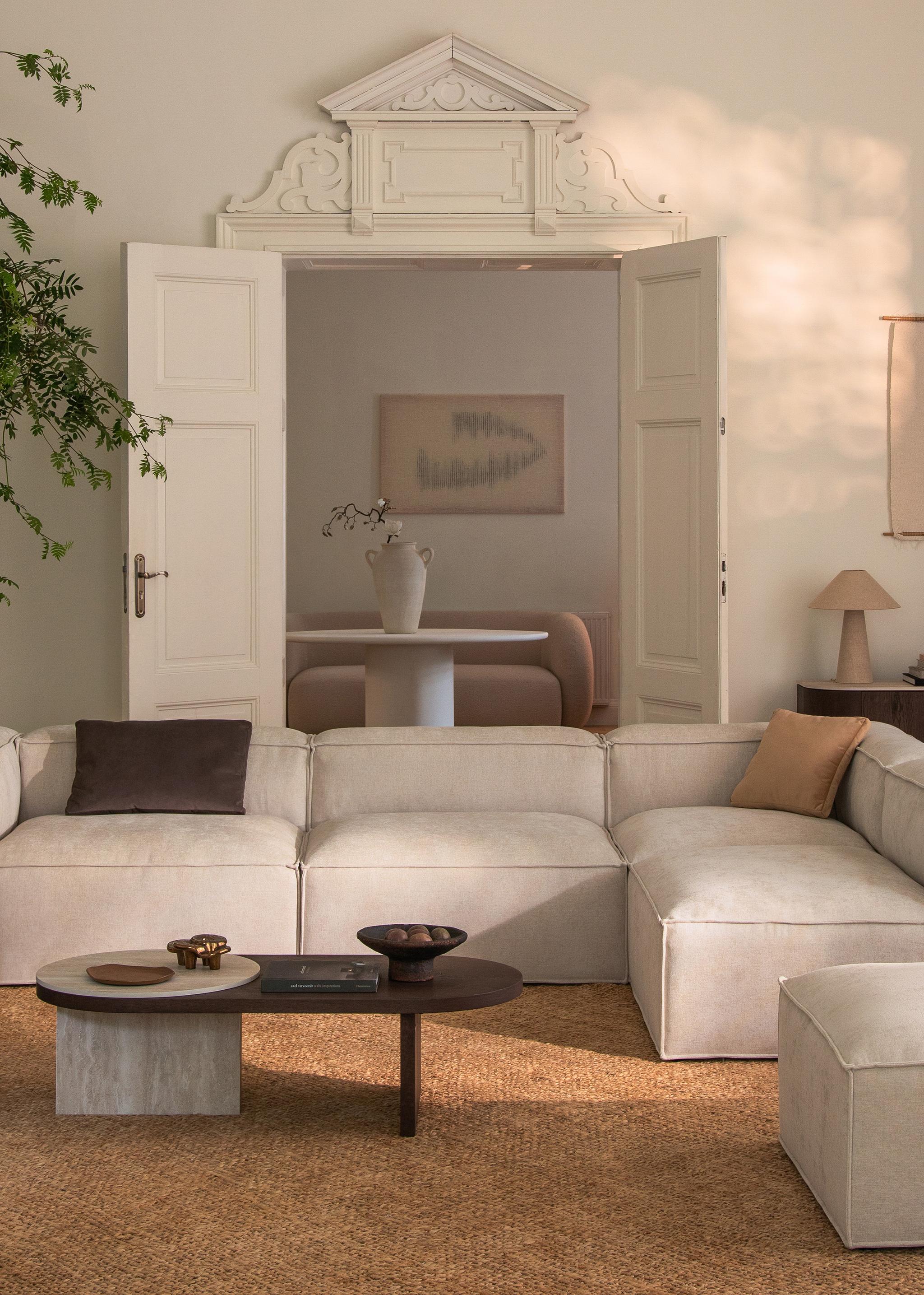 Canapé d’angle modulaire Nuria en tissu gris clair texturé avec accoudoirs droits et coussins assortis – mobilier Micadoni