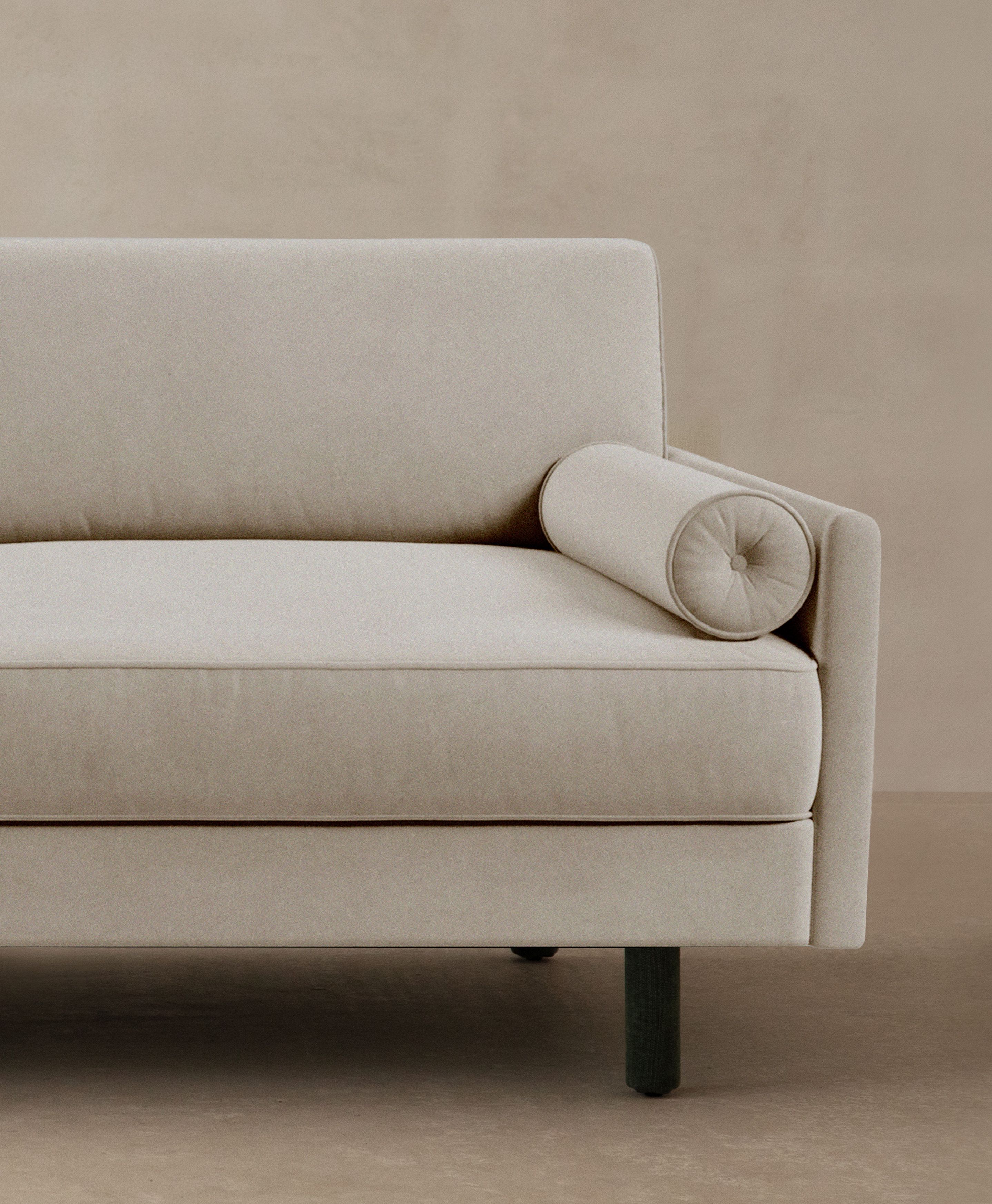 Canapé Scott en velours beige clair avec coussin rouleau et accoudoir fin – mobilier Micadoni