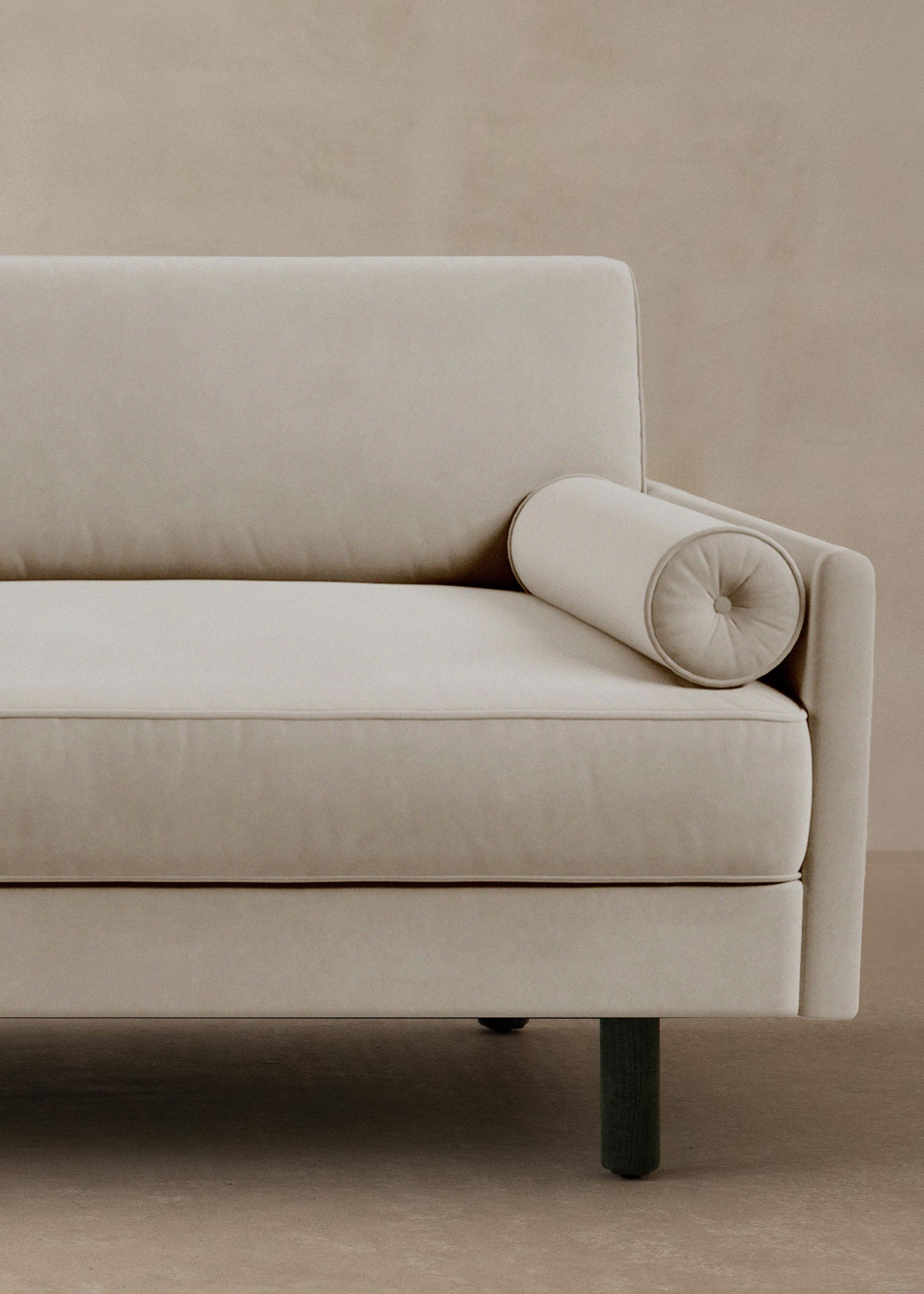 Canapé Scott en velours beige clair avec coussin rouleau et accoudoir fin – mobilier Micadoni