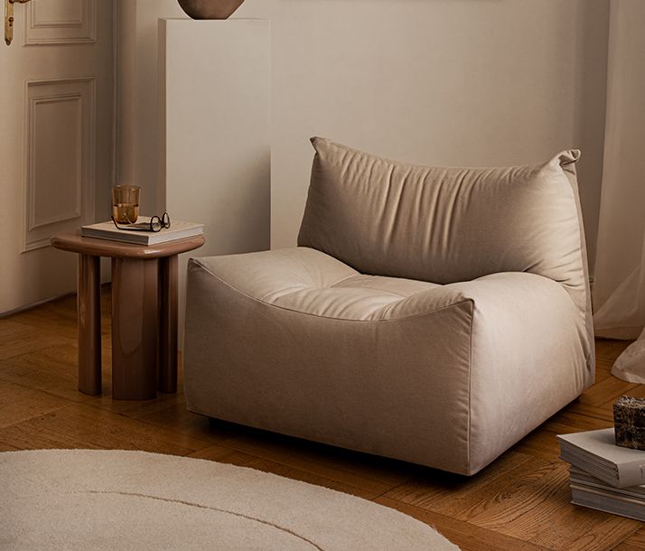 Salle à manger moderne Micadoni avec table ovale noire et quatre chaises capitonnées sombres, rideaux neutres, lumière du jour.